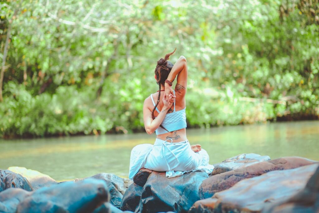 a girls is stretching beside a lake