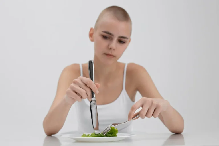 Young woman with hair loss eating a very small salad, illustrating hair loss linked to poor nutrition and protein deficiency.
