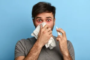 Man suffering from nasal congestion using tissue and nasal spray — concept of how to clear the nose and keep it clear to prevent mouth breathing at night