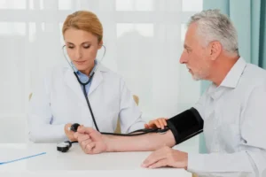 Doctor measuring blood pressure of an elderly patient during a health checkup in a medical clinic.