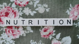 The word nutrition spelled out on floral fabric background, symbolizing healthy eating and balanced diet awareness.