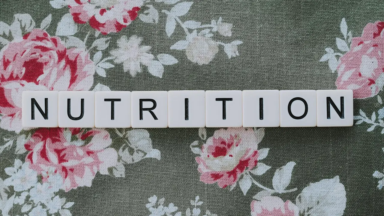 The word nutrition spelled out on floral fabric background, symbolizing healthy eating and balanced diet awareness.