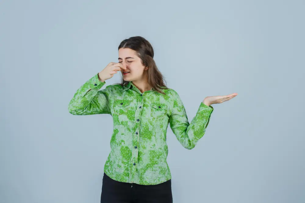 Woman holding her nose because of a bad smell symbolizing bad breath caused by cavities